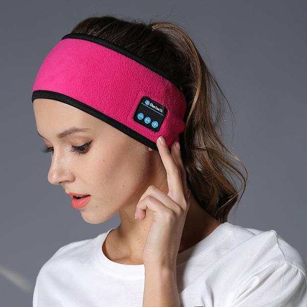Woman wearing pink wireless Bluetooth-compatible headband for outdoor fitness and yoga